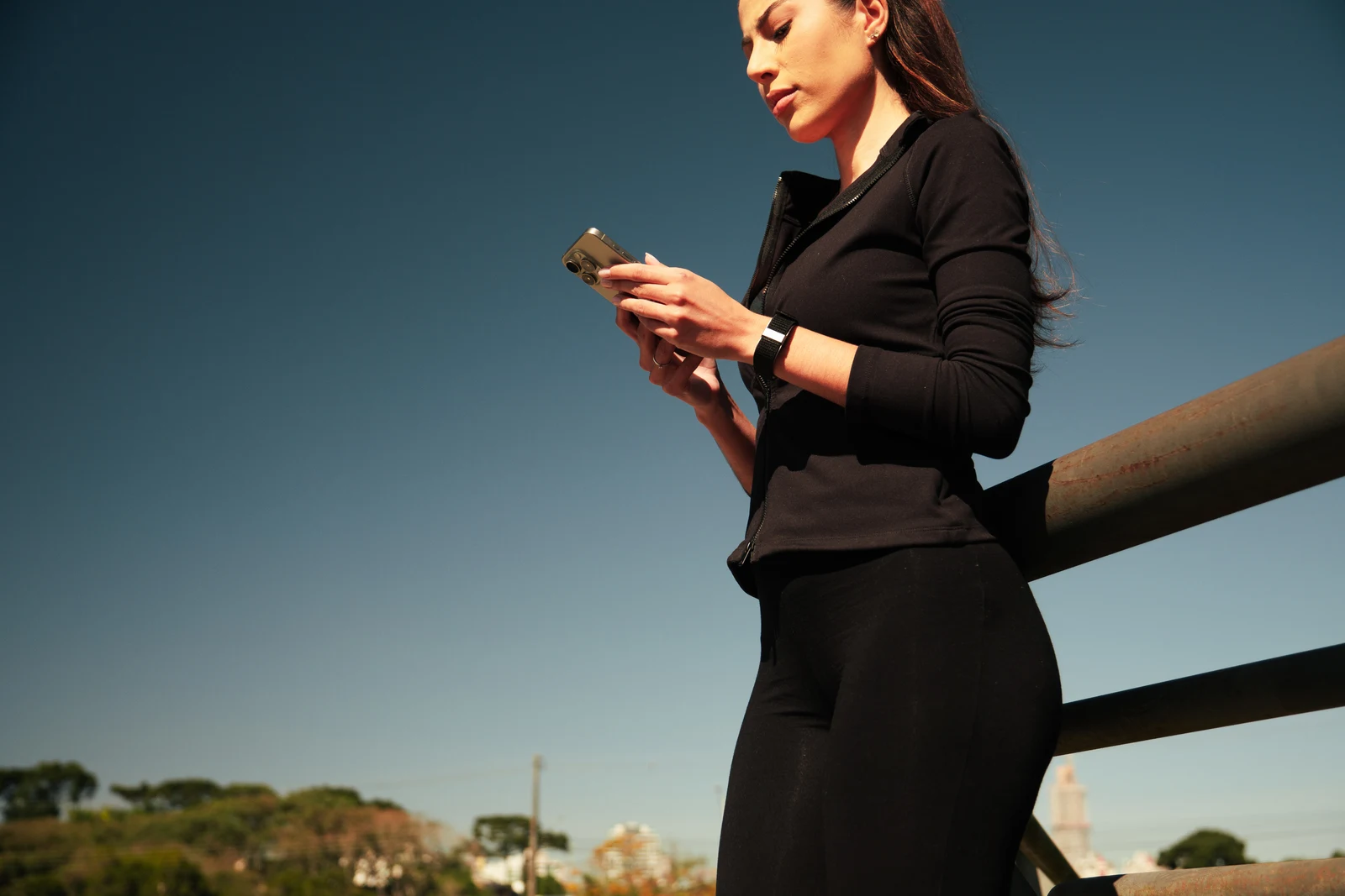 Woman wearing the band while checking her phone outdoors