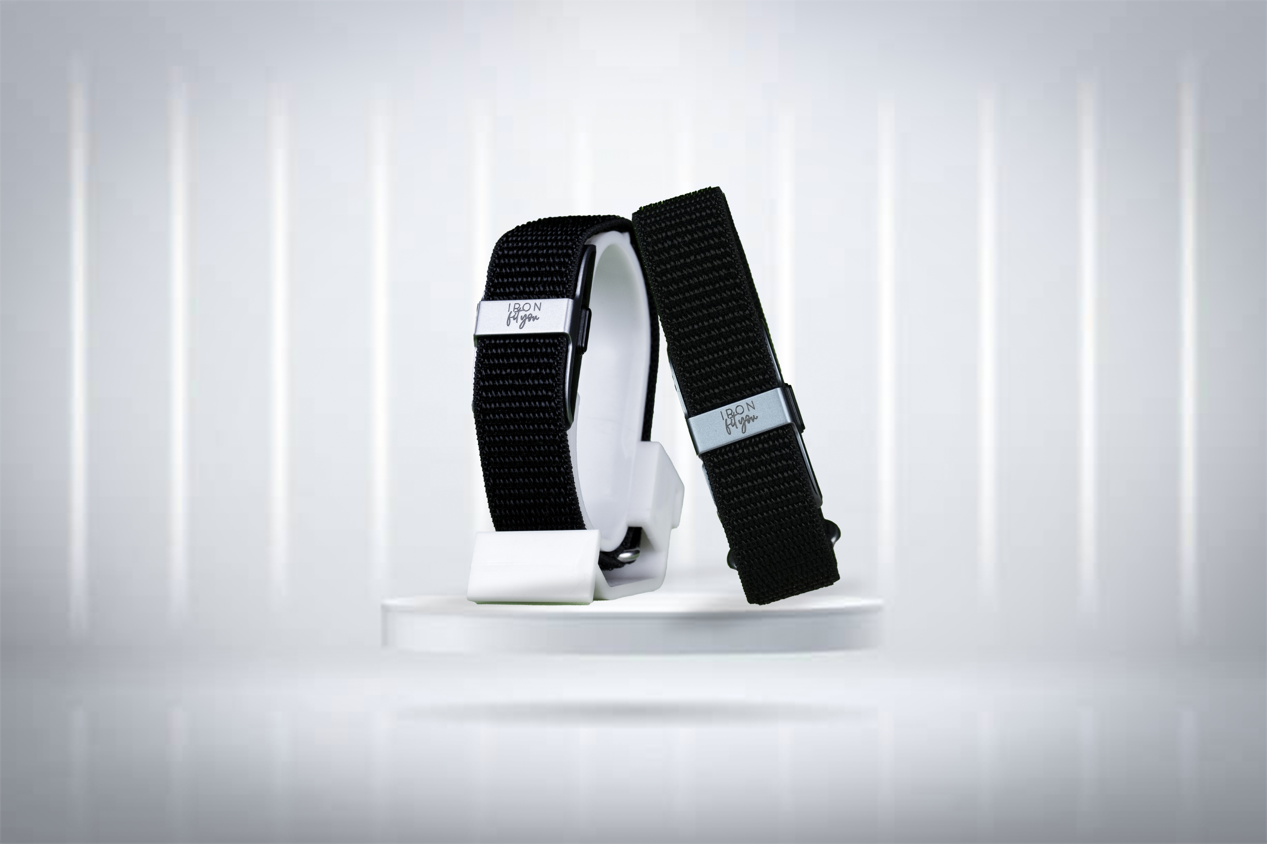 Black nylon IRON Fit You bands on a white display stand